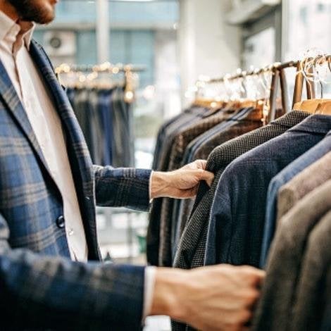 A man browsing through some tweed suits